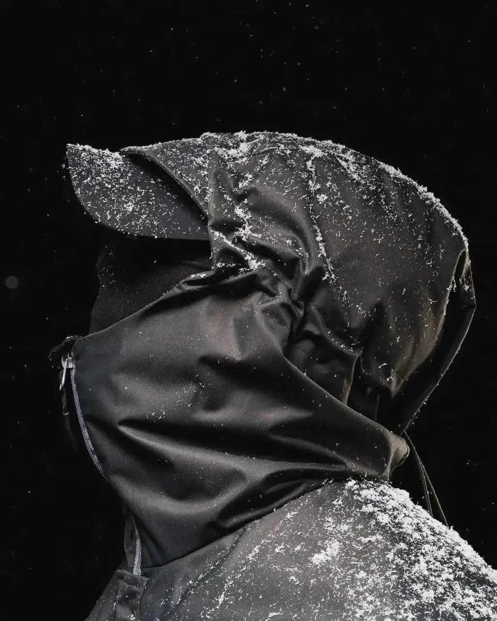 Мужчина в чёрной одежде, среди которой кепка, маска и ветровка бренда НЕАЛИТ